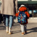 A mother entering the kindergarten yard with her preschooler boy. Childcare