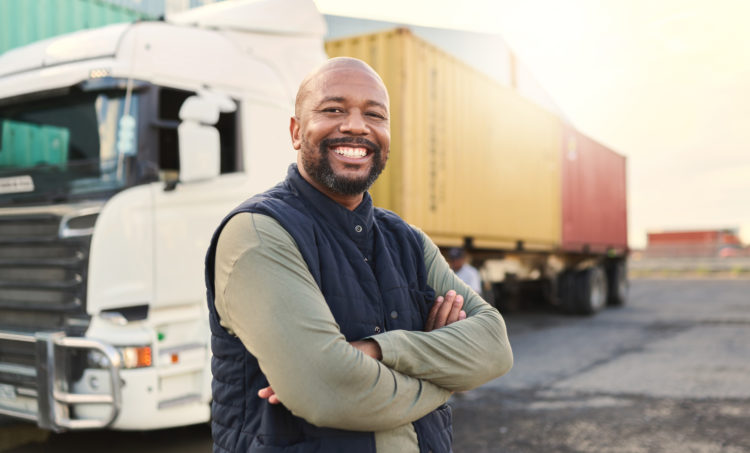 Delivery, container and happy truck driver moving industry cargo and freight at a shipping supply chain or warehouse. Smile, industrial and black man ready to transport ecommerce trade goods or stock.