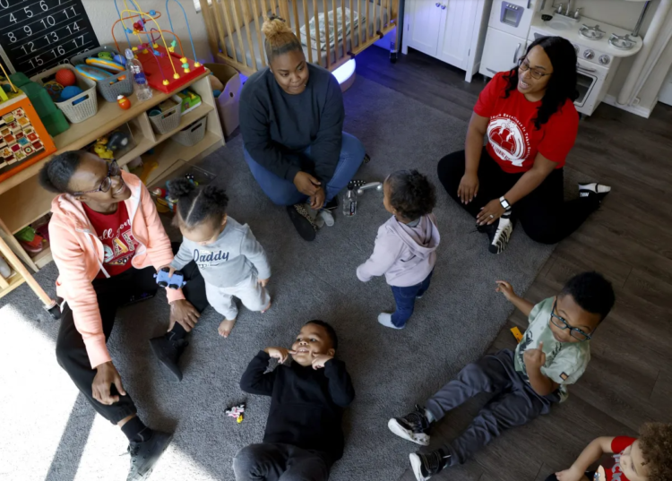 Jasmine Stewart (back right), and her assistant teachers Tarleace Johnson (back left) and Chant’e Stewart (back middle) play with students in Stewart’s sunroom, which serves as part of her in-home childcare, on March 13., 2023. Stewart said her goal is to grow her facility but extra requirements in Tulsa’s zoning code could push her to cut her capacity by three spots. (Rip Stell/For Oklahoma Watch)
