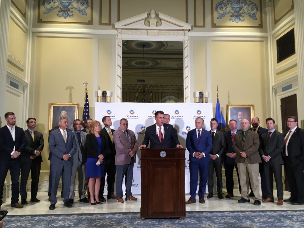 Gov. Kevin Stitt, flanked by legislators, announces a historic education package.