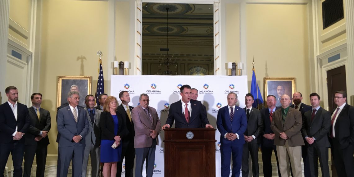Gov. Kevin Stitt, flanked by legislators, announces a historic education package.