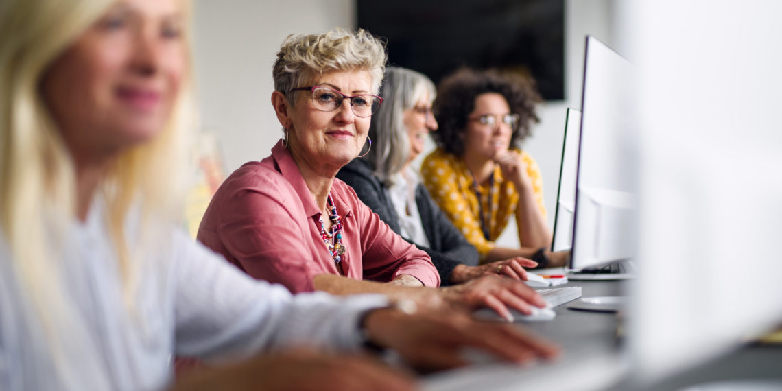 Group of senior people attending computer and technology education class, working.
