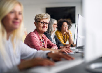 Group of senior people attending computer and technology education class, working.