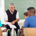 senior high school teacher teaching group of students in classroom