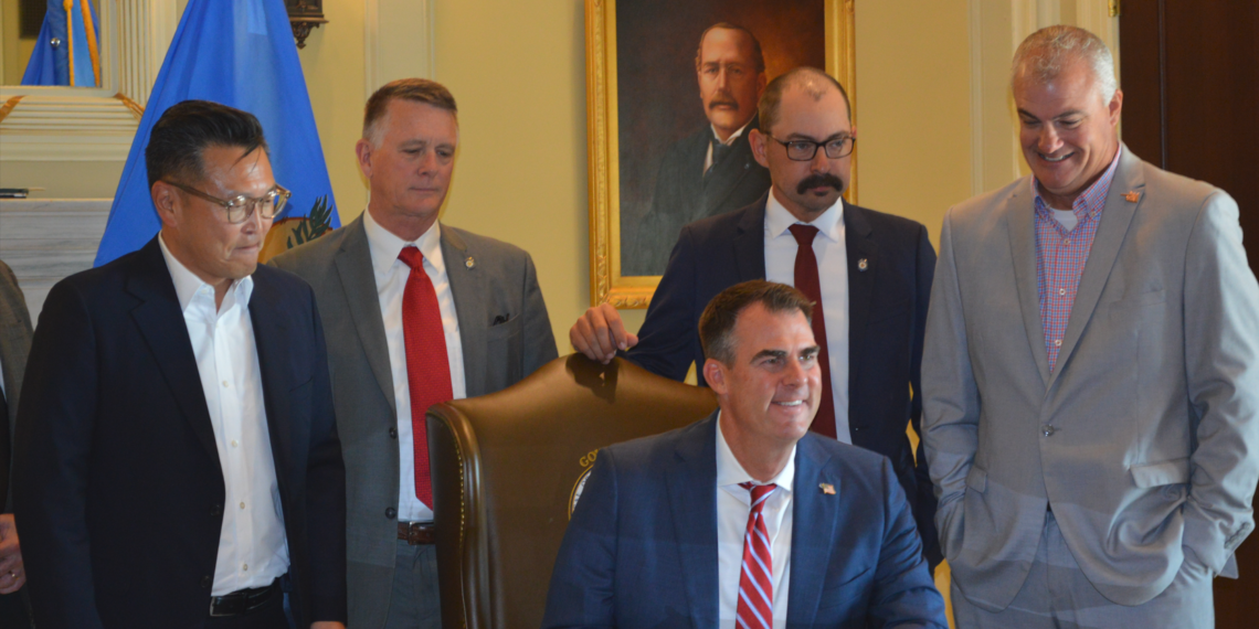 Gov. Kevin Stitt signs Blue Whale Materials' commitment to operate a plant in Bartlesville.
