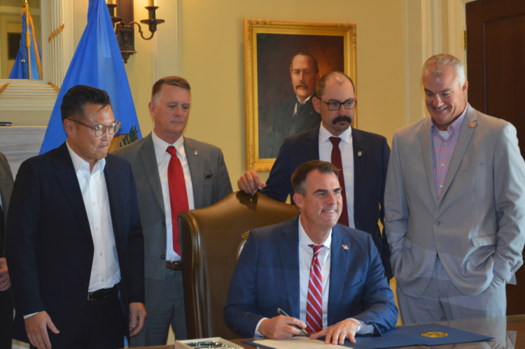 Gov. Kevin Stitt signs Blue Whale Materials' commitment to operate a plant in Bartlesville.