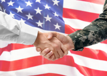 Soldier and civilian shaking hands on white background, closeup