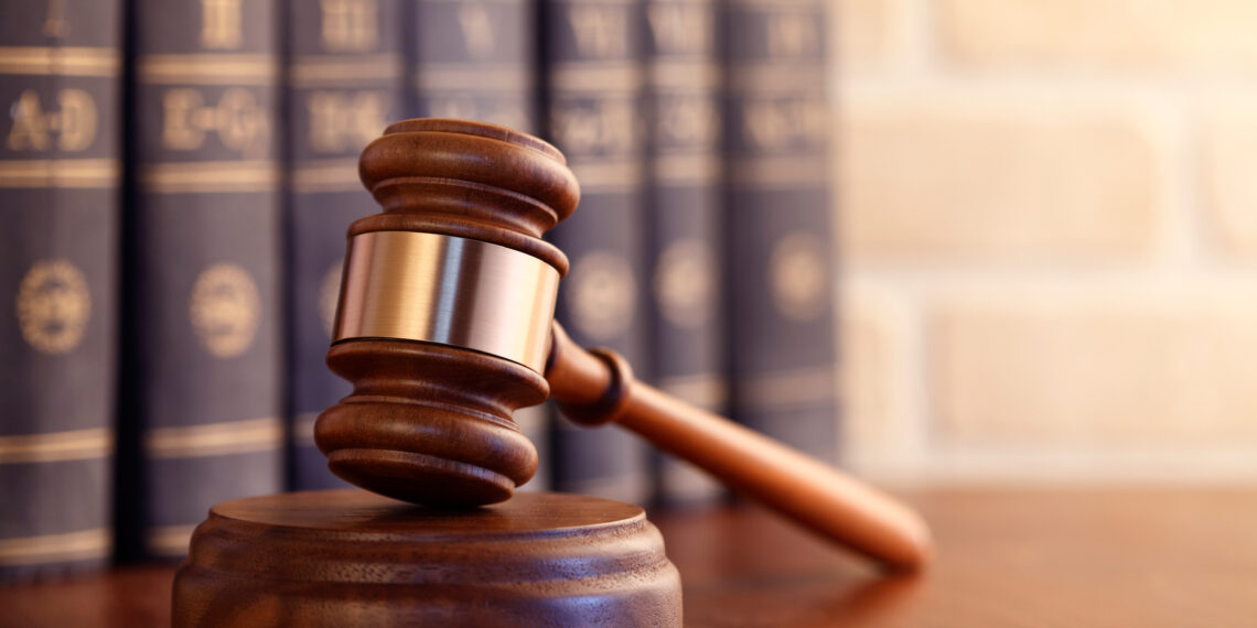 Gavel leaning against a row of law books