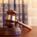 Gavel leaning against a row of law books