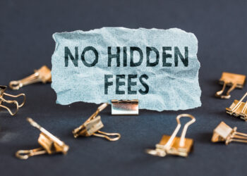 A scrap of blue paper with clips on a gray background with the text - NO HIDDEN FEES.