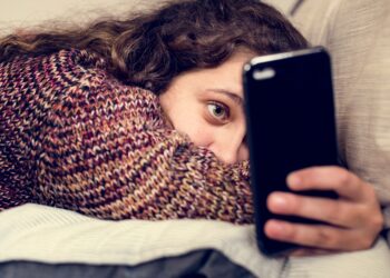 Teenage girl using a smartphone on a bed social media and addiction concept