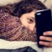 Teenage girl using a smartphone on a bed social media and addiction concept
