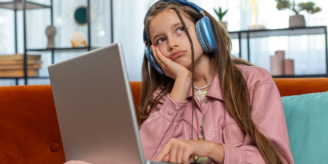 Tired young pupil girl student feeling boring with study or work at home. Stressed female teenage child exhausted from remote distance online education learning hard program on laptop computer indoors