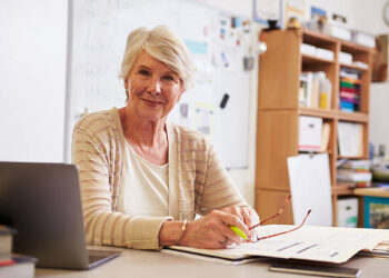 Portrait of senior female teacher working at her desk