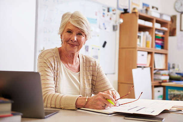 Portrait of senior female teacher working at her desk