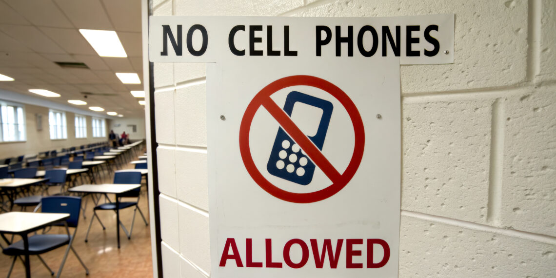 A sign prohibiting cell phones in a classroom, emphasizing a distraction-free environment for students.
