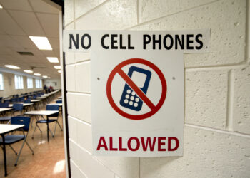 A sign prohibiting cell phones in a classroom, emphasizing a distraction-free environment for students.