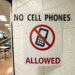 A sign prohibiting cell phones in a classroom, emphasizing a distraction-free environment for students.