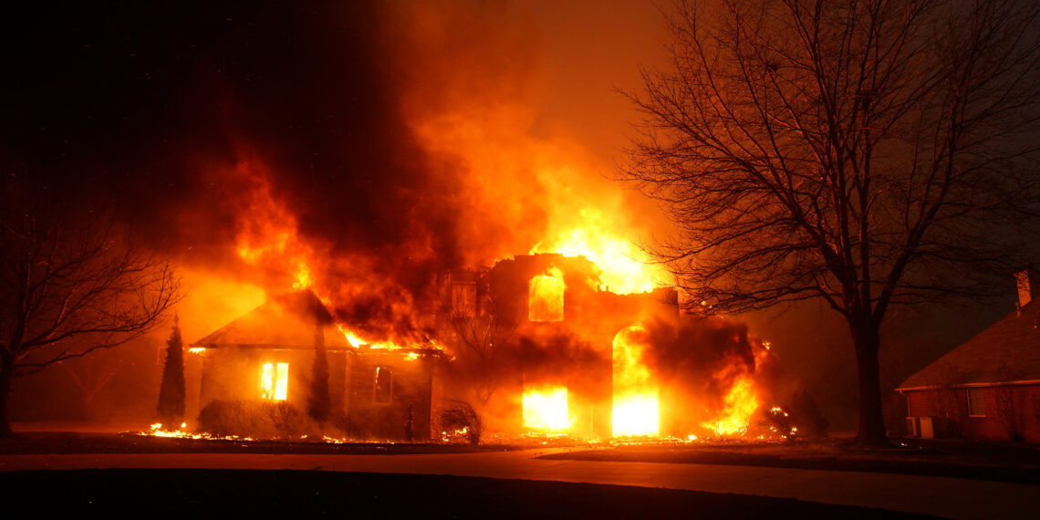 A residence burns as a wildfire outbreak spreads across Stillwater, Oklahoma, highlighting the devastation caused by wildfires to homes and communities in rural areas.