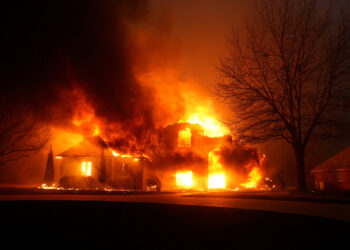 A residence burns as a wildfire outbreak spreads across Stillwater, Oklahoma, highlighting the devastation caused by wildfires to homes and communities in rural areas.