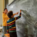 Young male science teacher explaining main rules and formulas in physics and mechanics for pupils. A boy is drawing on the blackboard. STEM disciplines, Math education concept tutoring tutor student teacher math