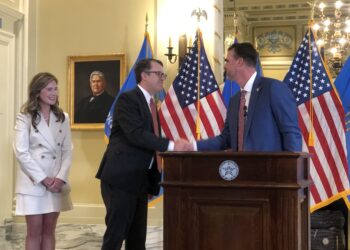 Gov. Kevin Stitt shakes Travis Jett's hand.