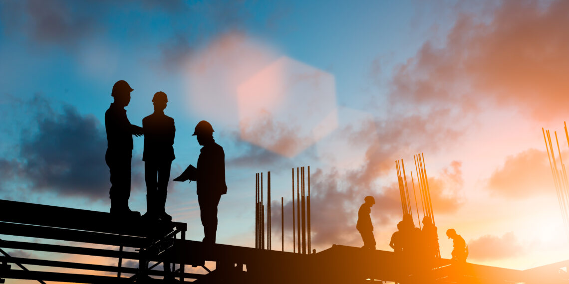 Silhouette engineer standing orders for construction and discuss