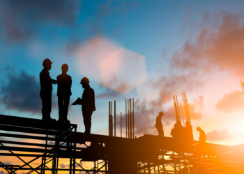 Silhouette engineer standing orders for construction and discuss