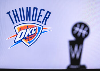 NEW YORK, USA, JUN 18, 2020: Oklahoma City Thunder Basketball club on the white screen. Silhouette of NBA trophy in foreground.
