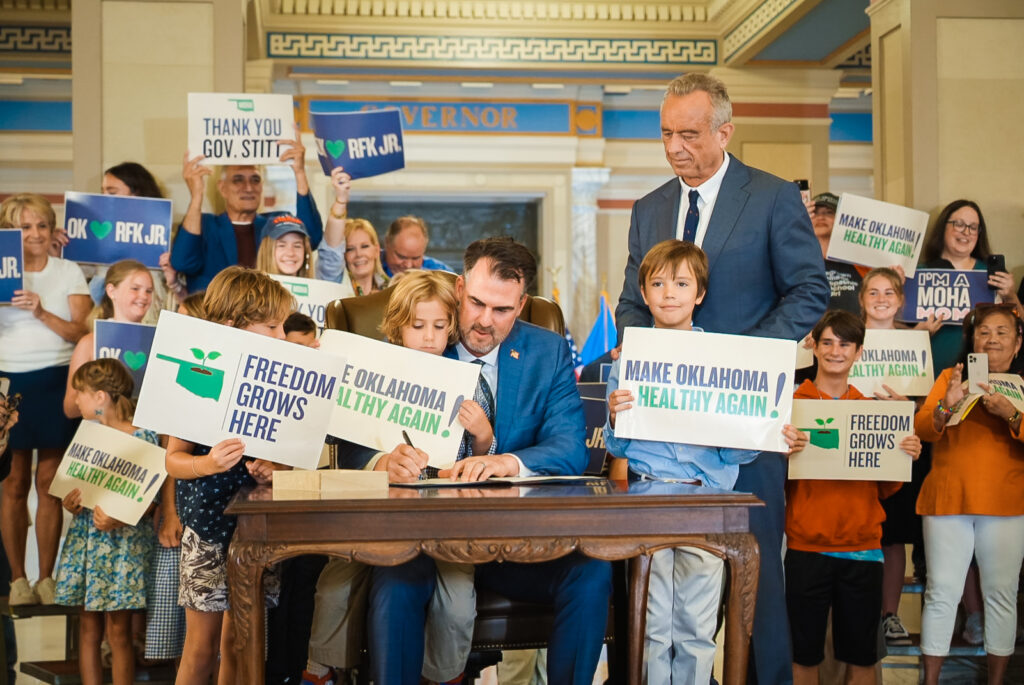 Gov. Kevin Stitt signs an executive order establishing Make Oklahoma Healthy again as U.S. Health and Human Services Secretary Robert F. Kennedy Jr. looks on. Photo from Stitt's office