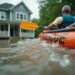 Flooding 2025. Rescuers in an inflatable rescue boat with the text 'Rescue' approach a flooded house to save residents trapped inside due to high water. AI-generated image