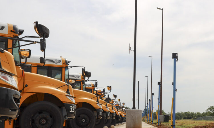 Rows of Deer Creek Public School busses parked alongside CNG fueling stations.