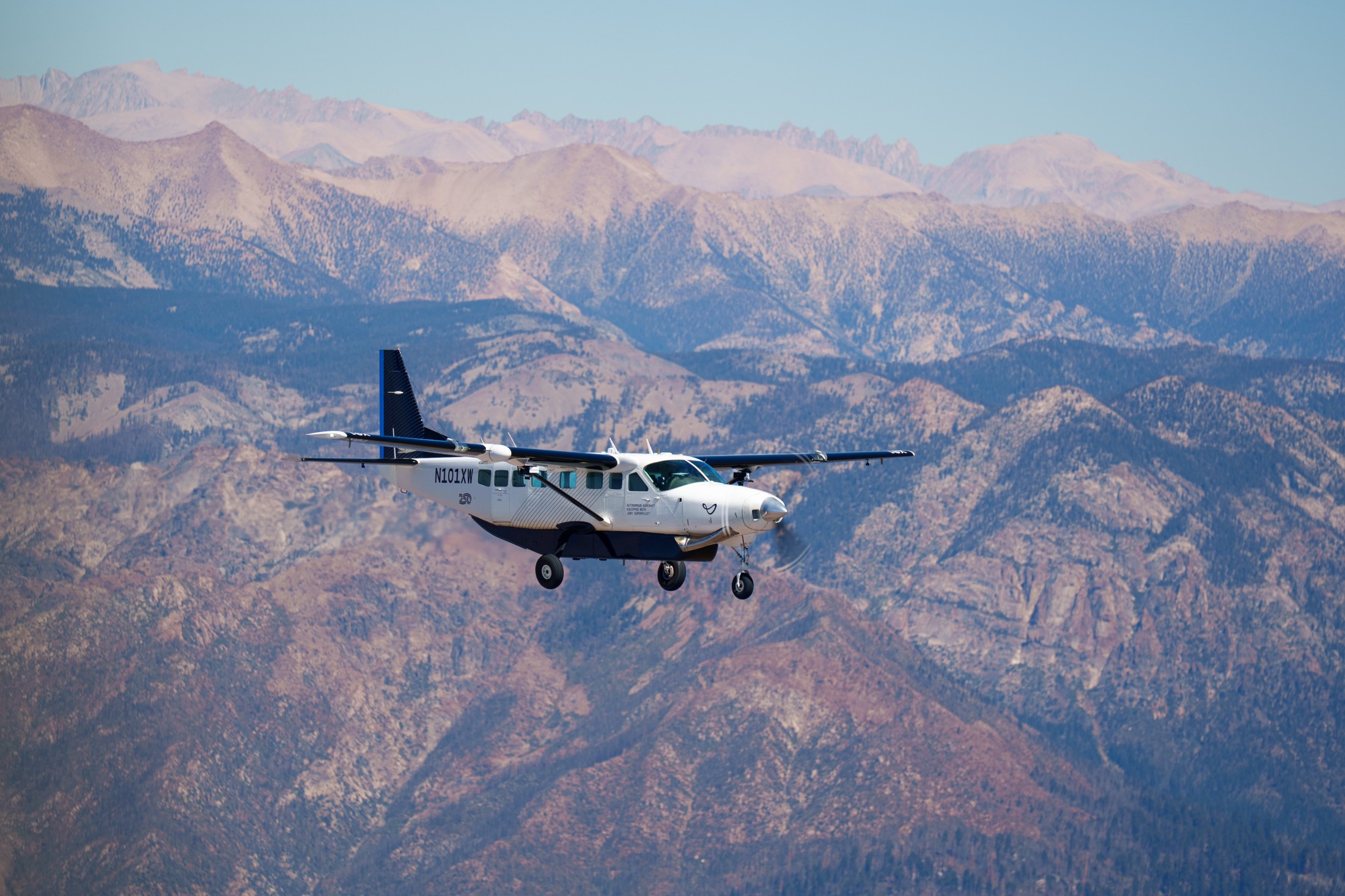 Joby’s autonomous J208 in flight in front of a mountain landscape.