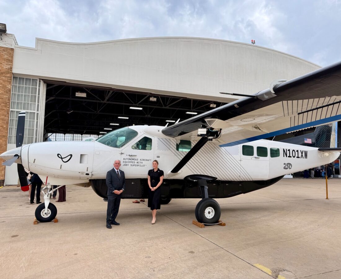 Sen. Paul Rosino and Rep. Emily Gise beside the Joby J208 outside an airport hangar.