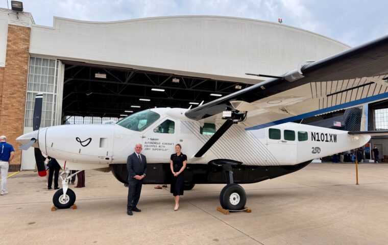 Sen. Paul Rosino and Rep. Emily Gise beside the Joby J208 outside an airport hangar.