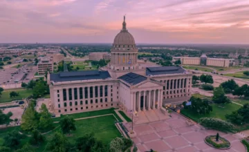 Aerial view of the Oklahoma State Capitol beneath a pink evening sky