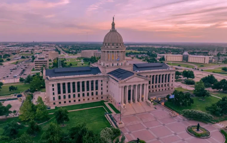 Aerial view of the Oklahoma State Capitol beneath a pink evening sky