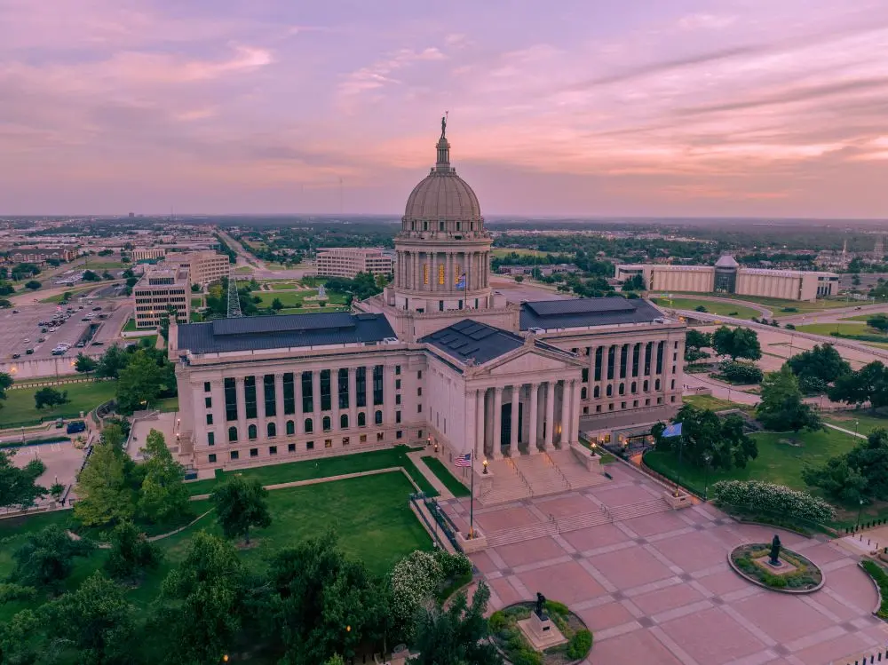 Aerial view of the Oklahoma State Capitol beneath a pink evening sky