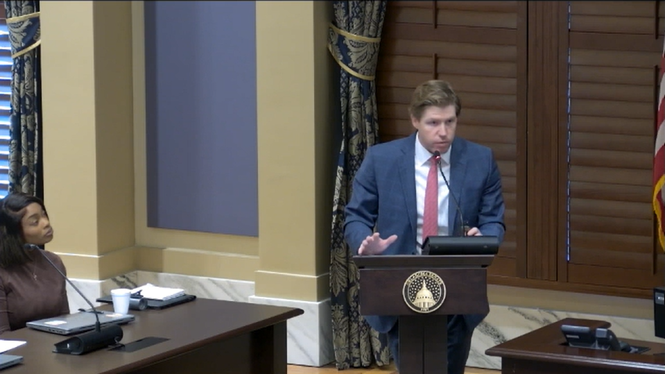 Adam Maxey testifies at a lectern during the Senate child care study.